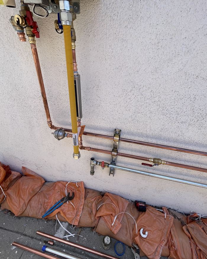New copper water lines and yellow gas line running to a tankless water heater