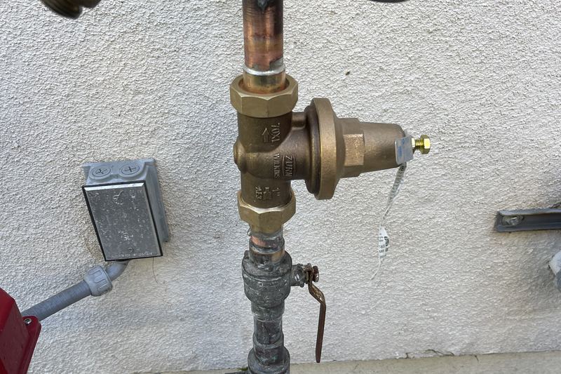 Brass pressure regulator and shutoff valve on a residential water main